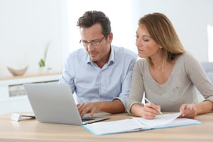 Couple at home working on contracting out agreement